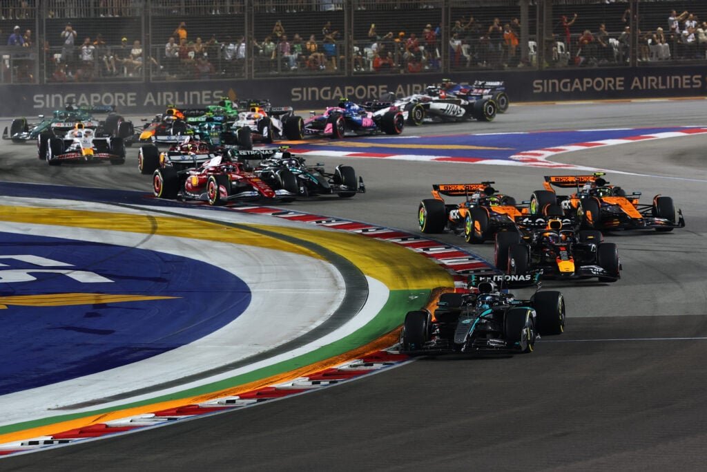 Lando Norris ultrapassa seu companheiro de equipe Oscar Piastri no início do Grande Prêmio de Cingapura de F1 de 2025